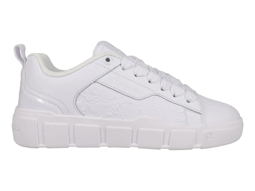 Tenis blancos Champion con detalle floral grabado en el lateral y suela blanca.