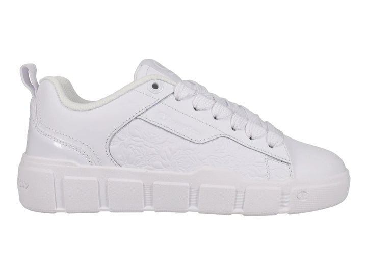 Tenis blancos Champion con detalle floral grabado en el lateral y suela blanca.