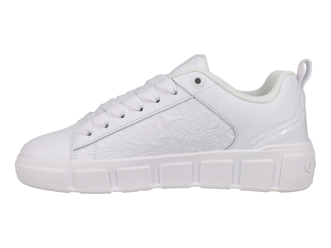 Tenis blancos Champion con detalle floral grabado en el lateral y suela blanca.