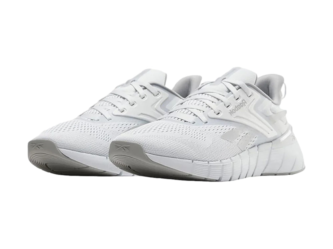 Tenis deportivos Reebok Nano Gym en color gris con detalles blancos y suela blanca texturizada.