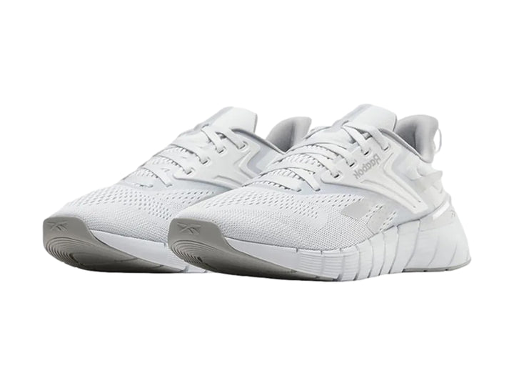 Tenis deportivos Reebok Nano Gym en color gris con detalles blancos y suela blanca texturizada.