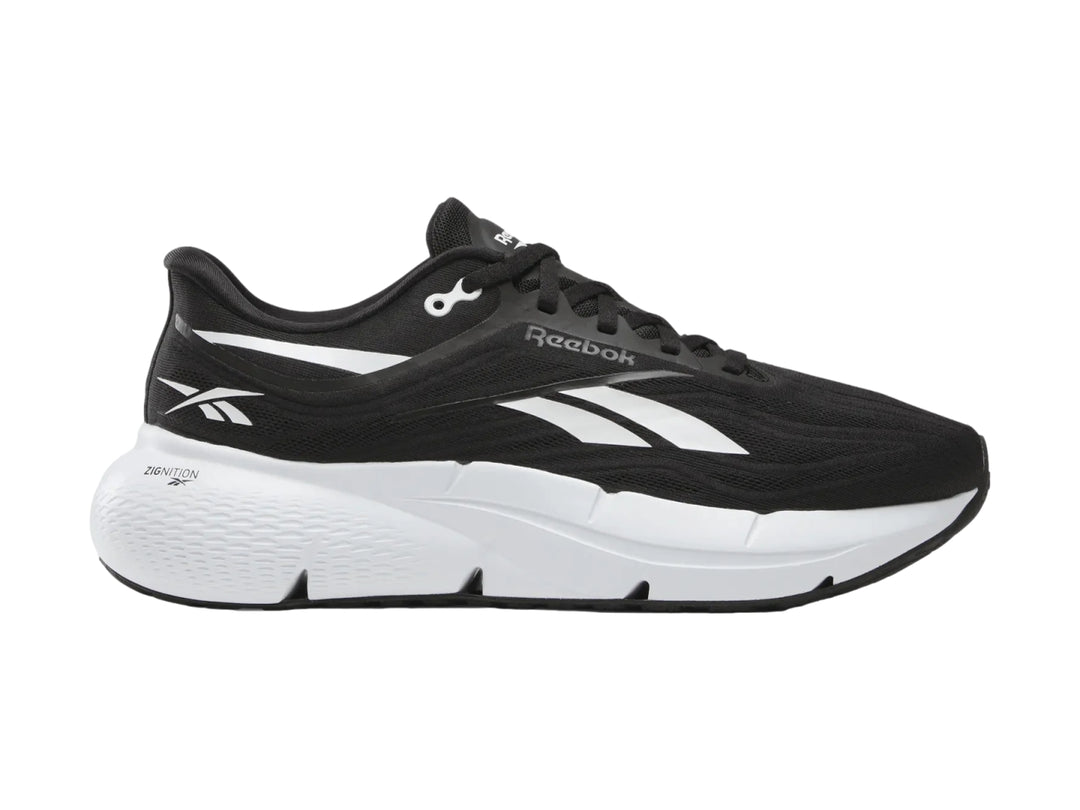 Tenis deportivos Reebok color negro con suela blanca y detalles laterales blancos.
