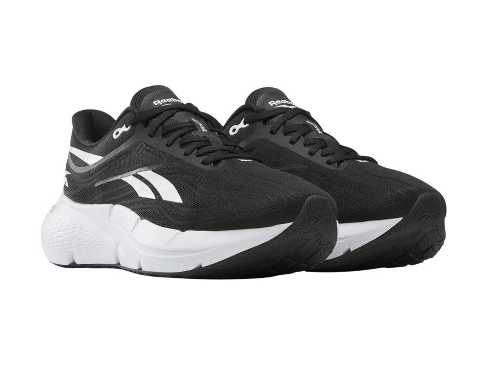 Tenis deportivos Reebok color negro con suela blanca y detalles laterales blancos.
