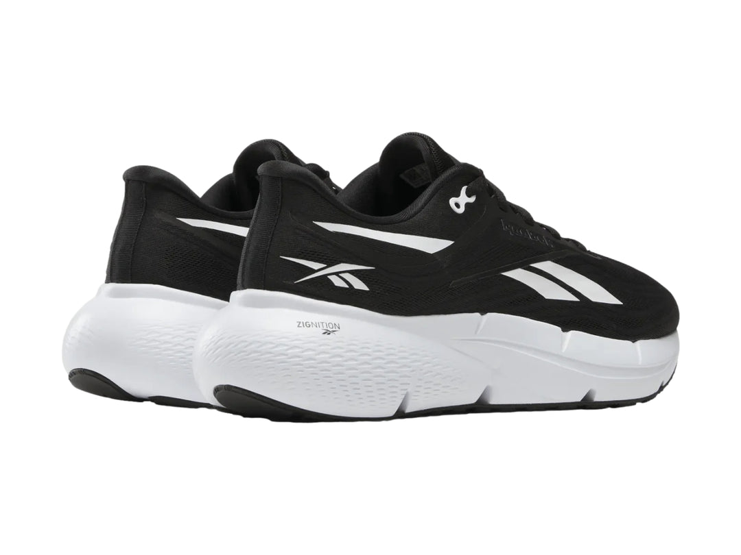 Tenis deportivos Reebok color negro con suela blanca y detalles laterales blancos.