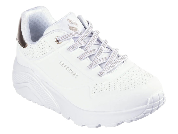 Tenis blancos Skechers con detalle dorado en el talón y suela blanca gruesa.