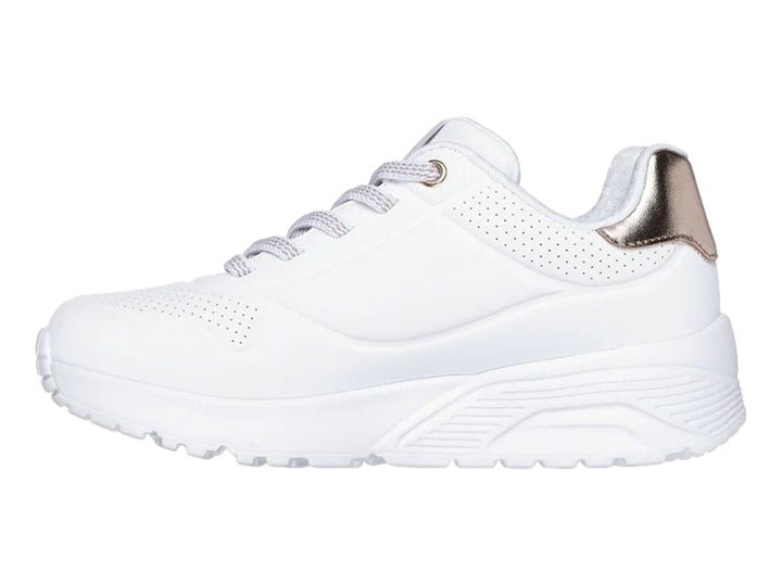 Tenis blancos Skechers con detalle dorado en el talón y suela blanca gruesa.