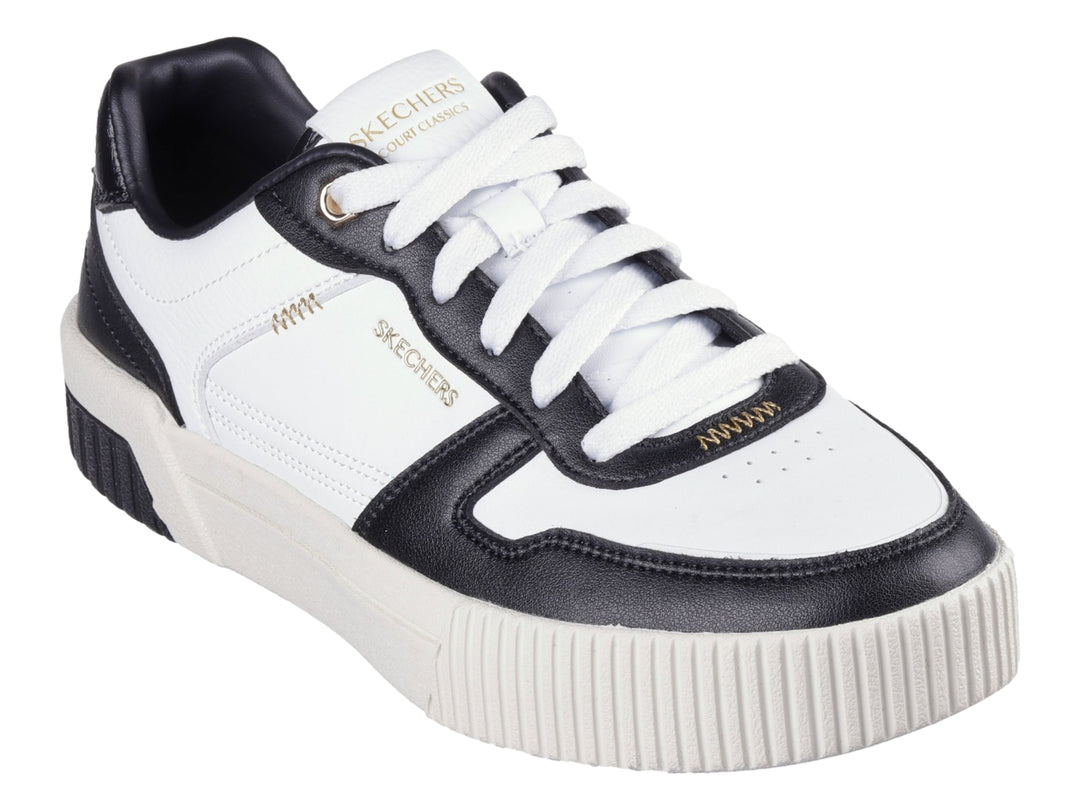 Tenis Skechers blancos con detalles en negro y suela blanca con talón negro.