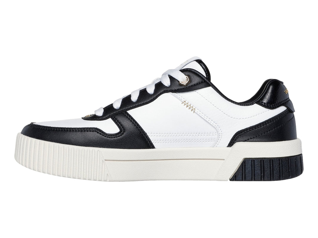 Tenis Skechers blancos con detalles en negro y suela blanca con talón negro.