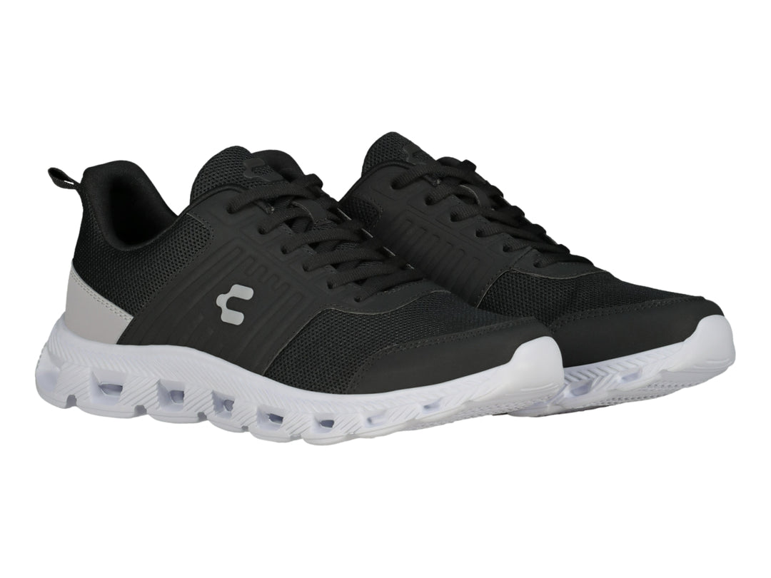 Tenis deportivos Charly color negro con suela blanca y detalle gris en el talón.