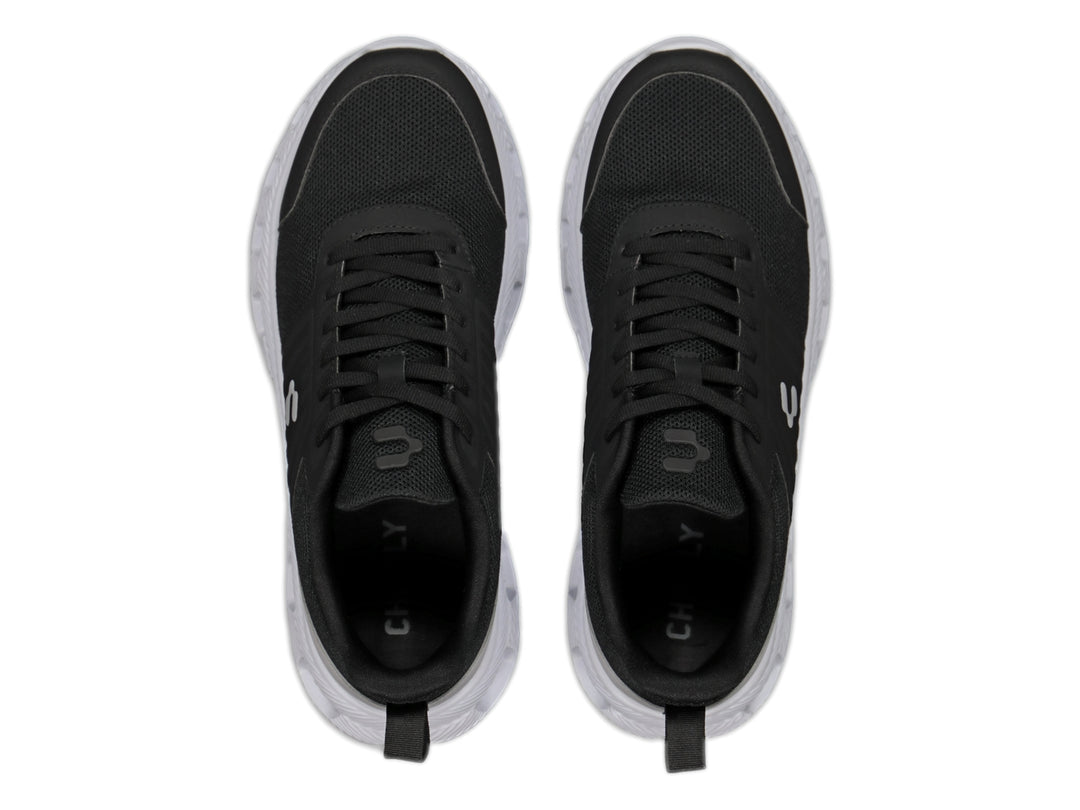 Tenis deportivos Charly color negro con suela blanca y detalle gris en el talón.