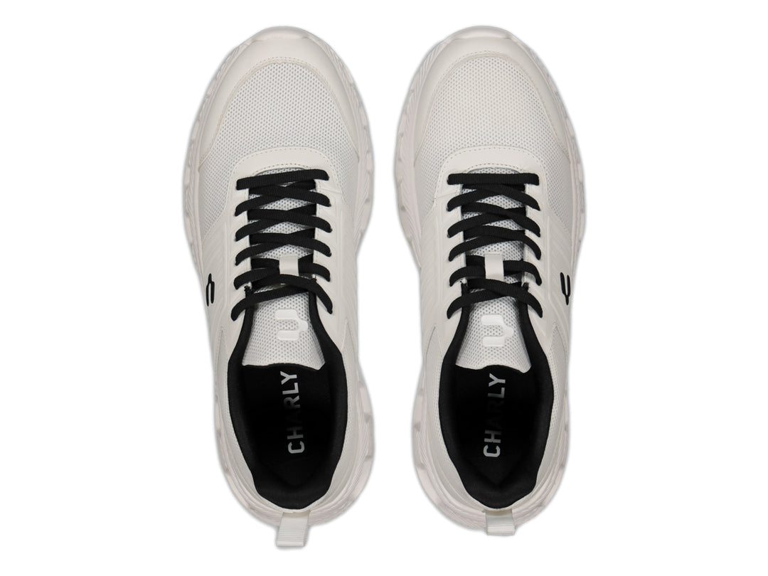 Tenis deportivos Charly color blanco con detalles en negro y suela blanca.