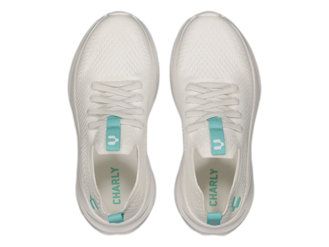 Tenis deportivos Charly color blanco con detalles en aqua, diseño de tejido ligero y suela blanca robusta.