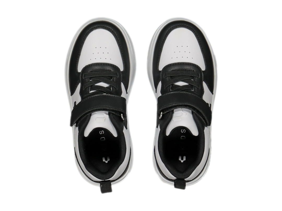 Tenis Charly para niño en colores blanco y negro con cierre de velcro y suela blanca.