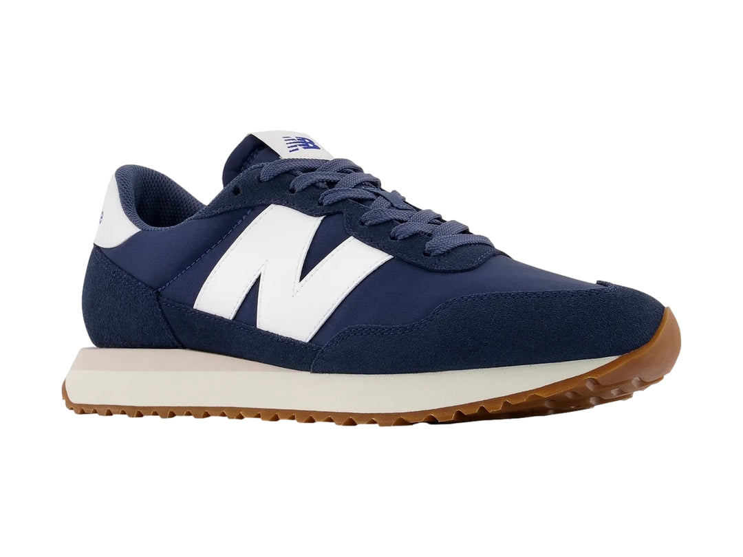 Tenis New Balance modelo 237 en color azul vintage indigo con detalles blancos y suela de goma café.