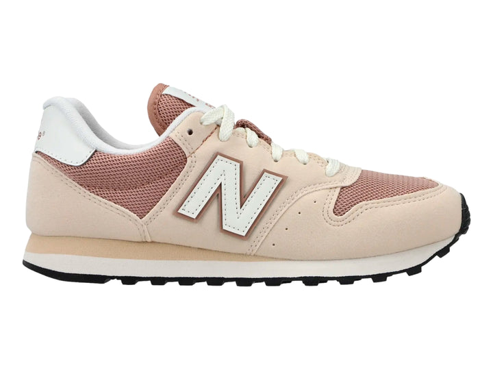 Tenis New Balance en colores beige y rosa con suela negra y detalles en blanco.