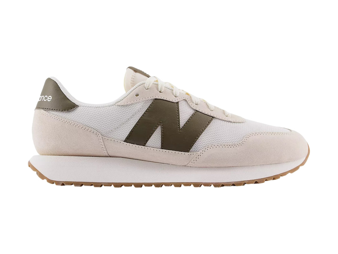 Tenis New Balance color blanco crema con detalles en gamuza y suela color caramelo.