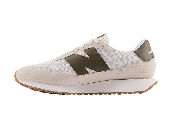 Tenis New Balance color blanco crema con detalles en gamuza y suela color caramelo.