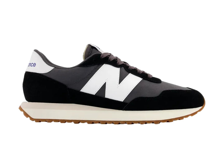 Tenis New Balance modelo 237 color negro con suela blanca y base marrón.