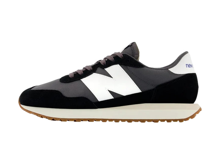 Tenis New Balance modelo 237 color negro con suela blanca y base marrón.