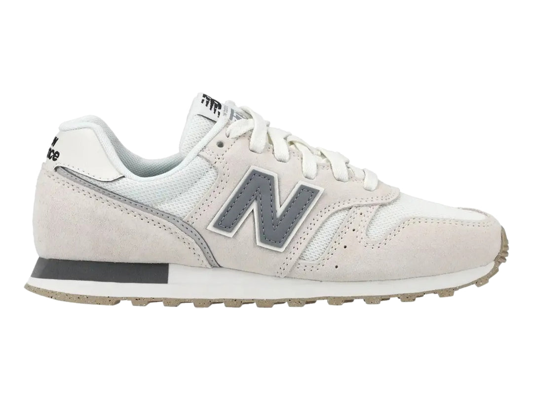 Tenis New Balance color lino con detalles en gris y blanco, vista lateral.