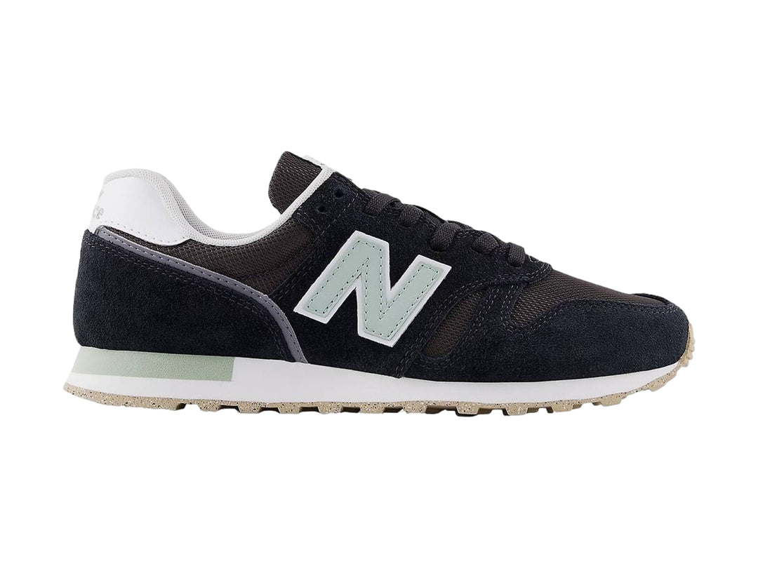 Tenis New Balance modelo 373 en color negro con detalles en blanco y gris, vista lateral.