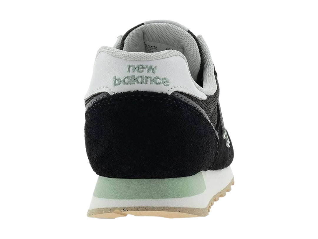Tenis New Balance modelo 373 en color negro con detalles en blanco y gris, vista lateral.