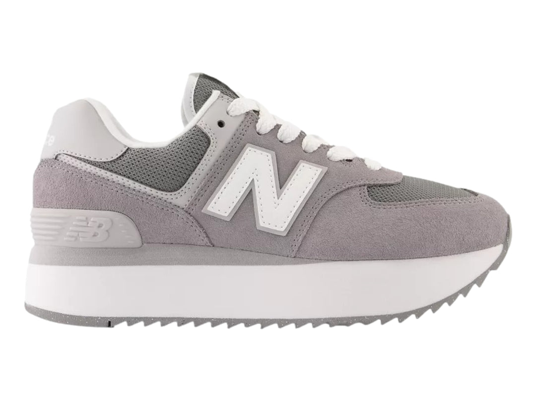 Tenis New Balance modelo 574 en color gris con suela de plataforma blanca y detalles en malla.