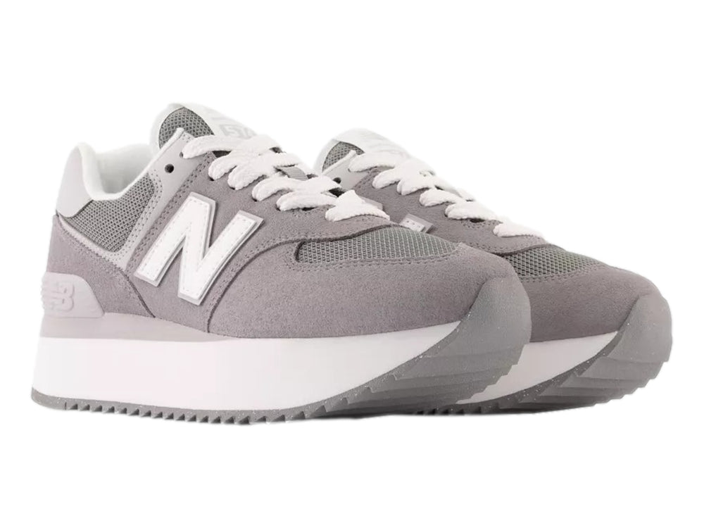 Tenis New Balance modelo 574 en color gris con suela de plataforma blanca y detalles en malla.