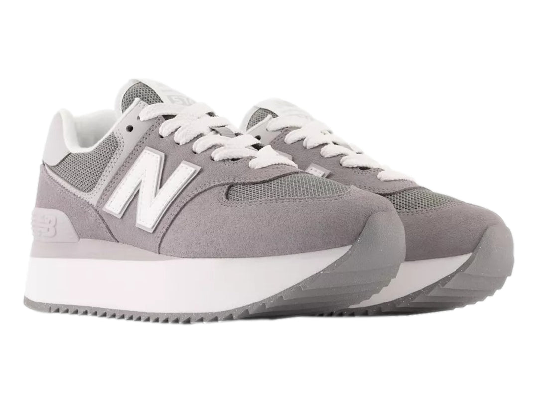 Tenis New Balance modelo 574 en color gris con suela de plataforma blanca y detalles en malla.