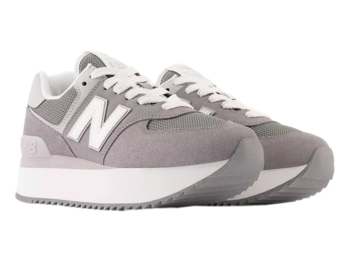 Tenis New Balance modelo 574 en color gris con suela de plataforma blanca y detalles en malla.