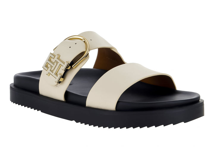 Sandalia mule Tommy Hilfiger de cuero con suela negra gruesa y correas blancas con hebilla dorada.