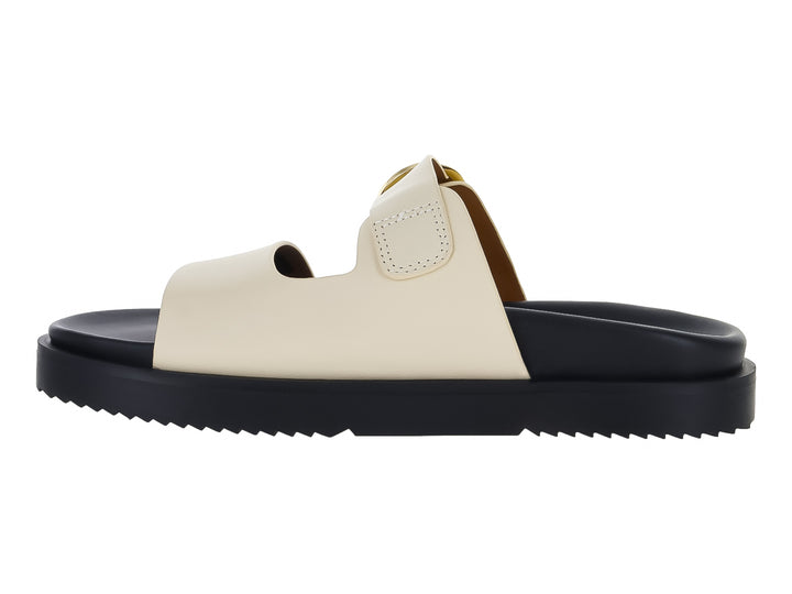 Sandalia mule Tommy Hilfiger de cuero con suela negra gruesa y correas blancas con hebilla dorada.