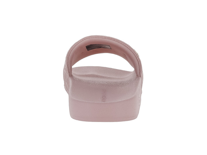 Sandalia deslizante Tommy Hilfiger en color rosa con banda superior texturizada y logotipo metálico dorado.