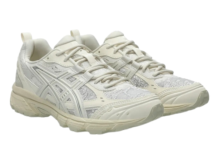 Tenis deportivos ASICS Gel-Nunobiki en color crema y plata con suela gruesa y detalles en malla.