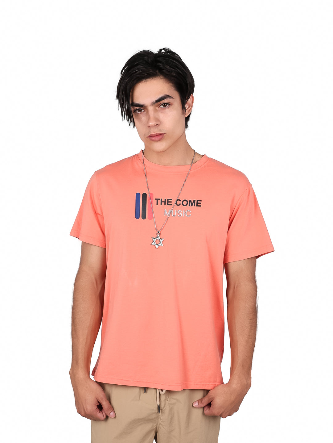 Hombre vistiendo playera color coral con estampado frontal y cuello redondo.