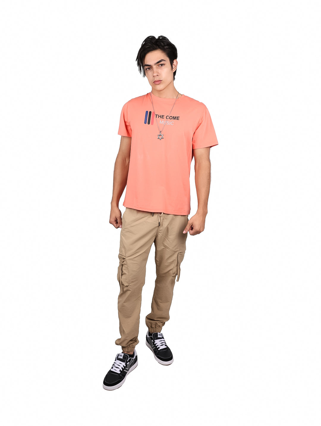 Hombre vistiendo playera color coral con estampado frontal y cuello redondo.