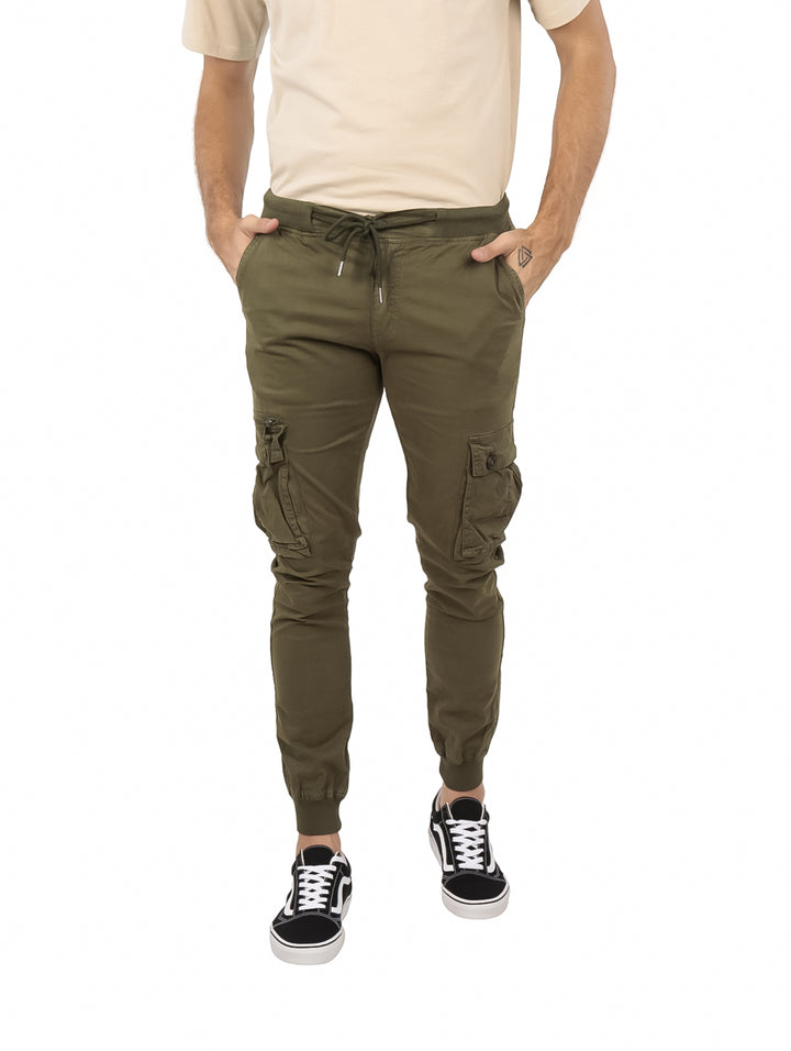 Hombre vistiendo pantalones jogger color verde militar con bolsillos laterales cargo y cintura ajustable.
