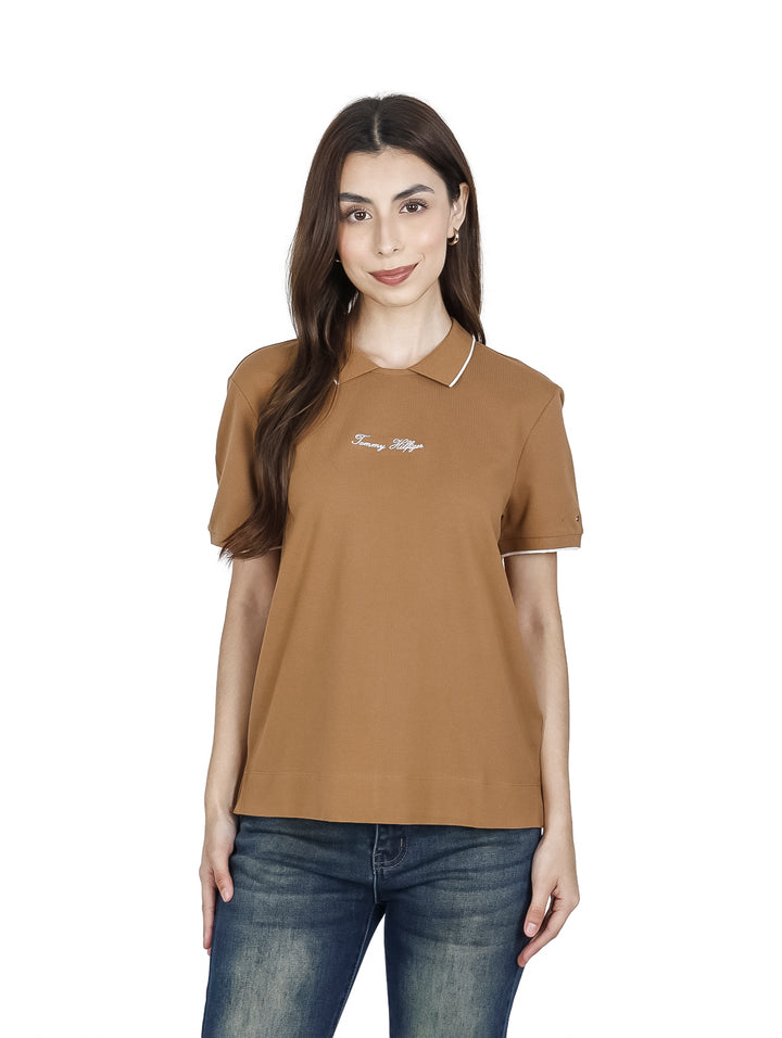 Mujer vistiendo una camisa marrón de manga corta con detalles blancos de la marca Tommy Hilfiger.