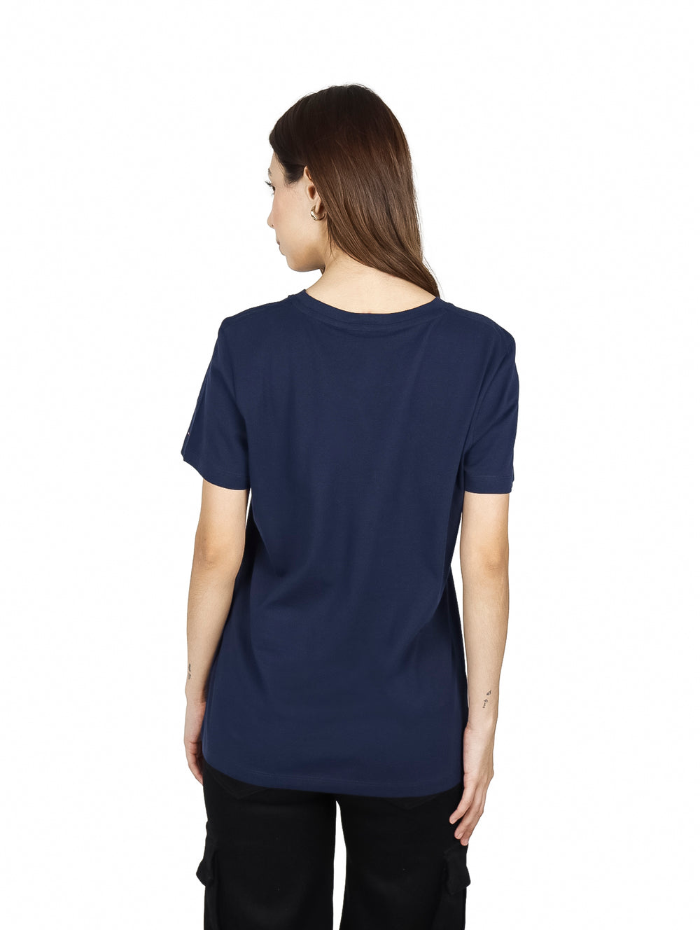 Mujer vistiendo playera azul marino de manga corta con logotipo de Tommy Hilfiger en el pecho.
