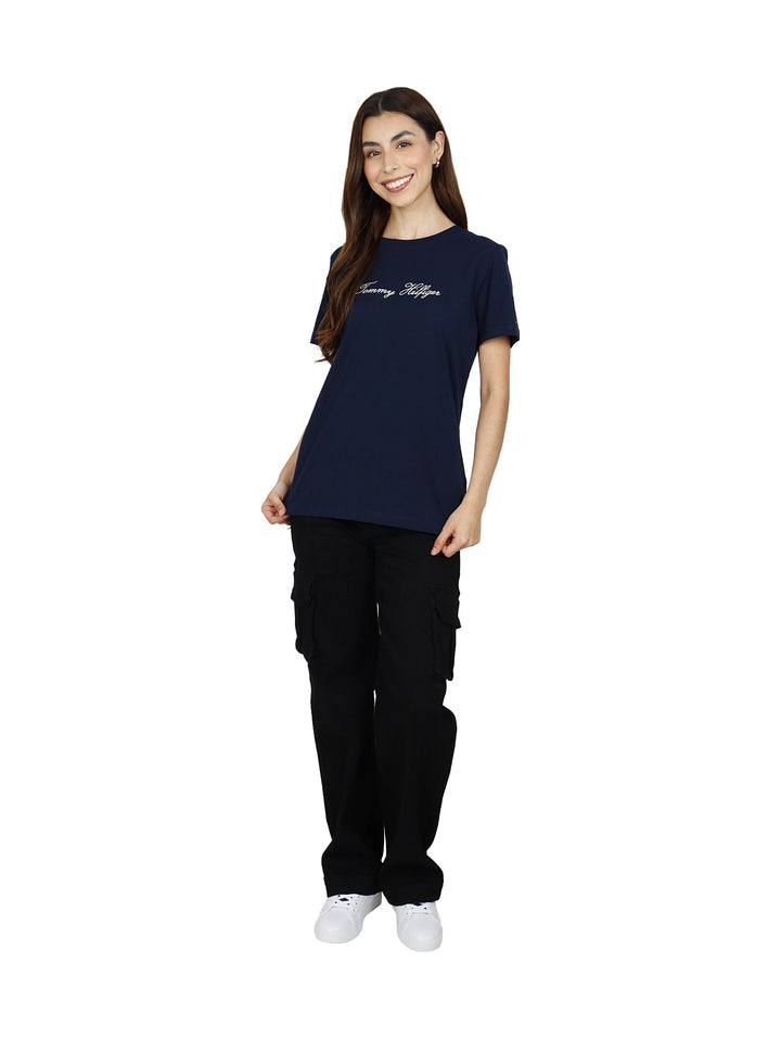 Mujer vistiendo playera azul marino de manga corta con logotipo de Tommy Hilfiger en el pecho.