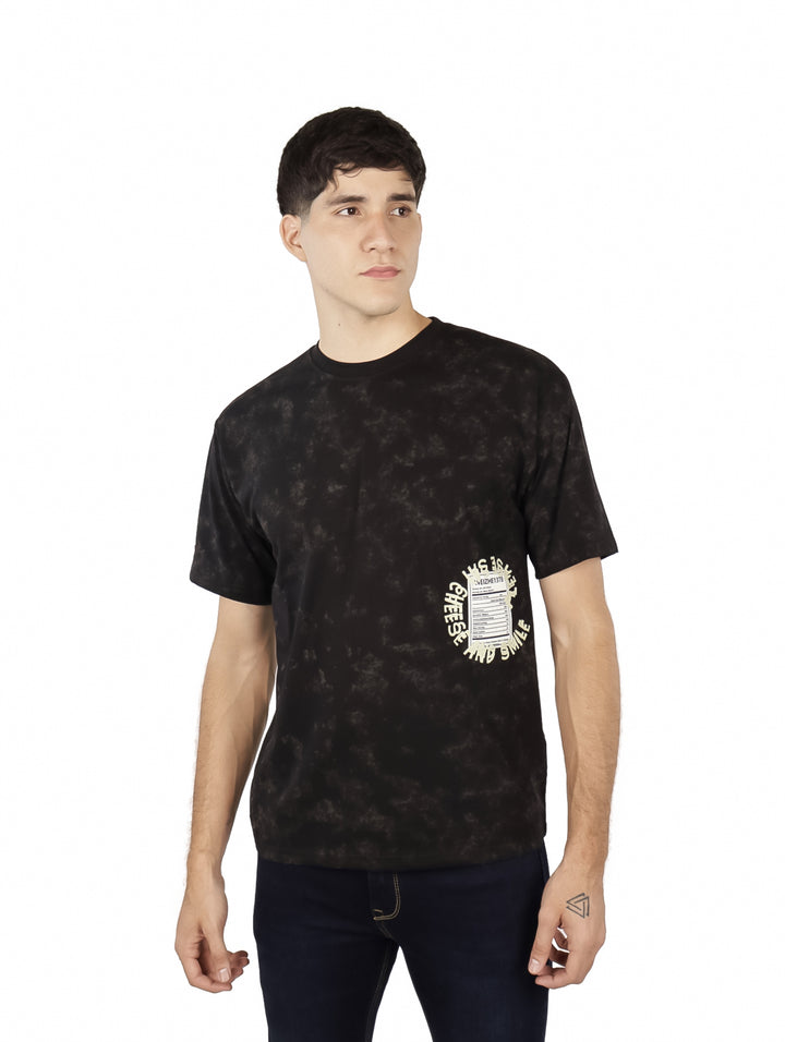 Hombre vistiendo playera oversize color negro con estampado gráfico lateral y cuello redondo.