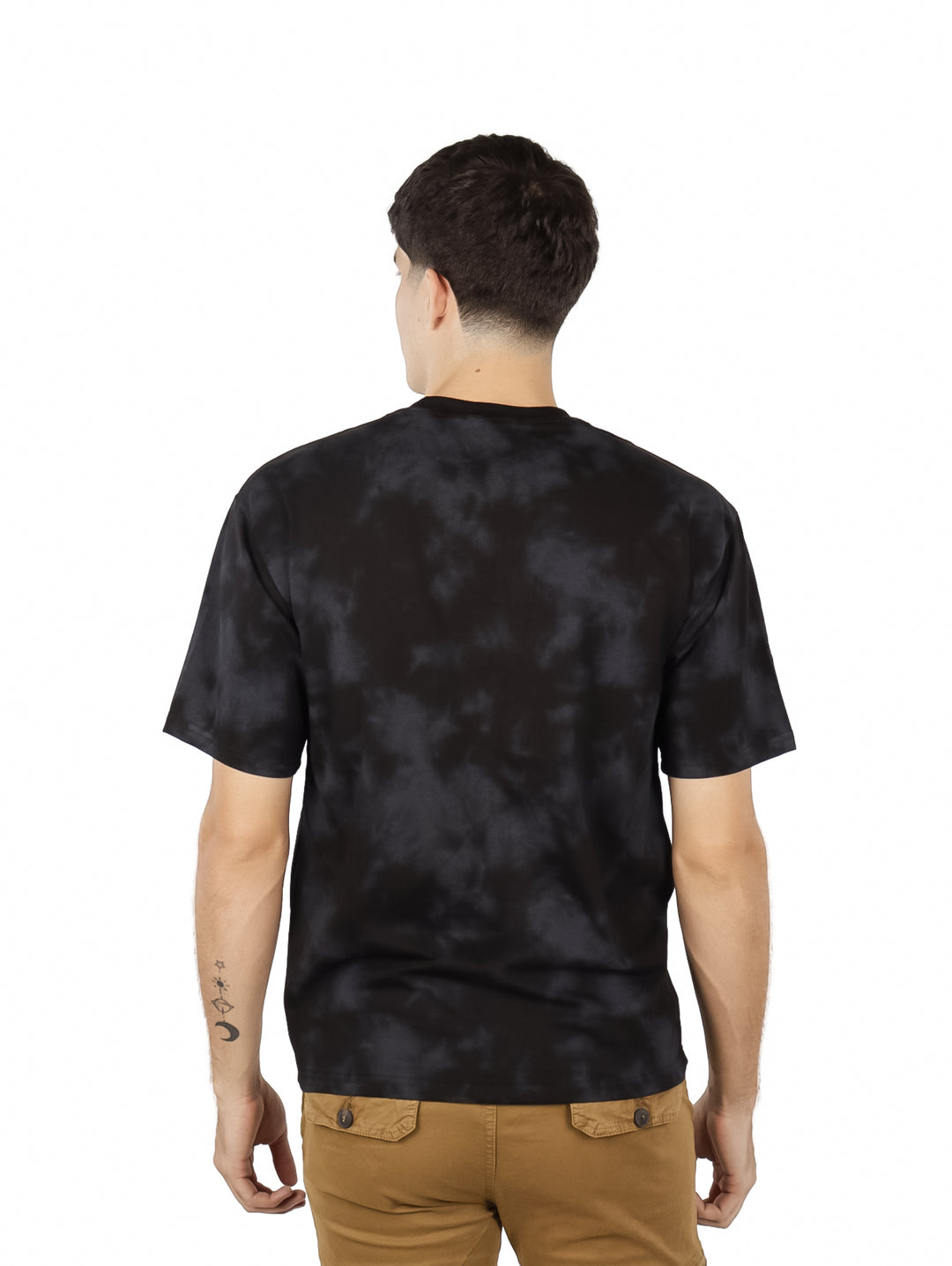 Hombre vistiendo playera oversize color negro con efecto tie-dye y estampado blanco en el pecho.