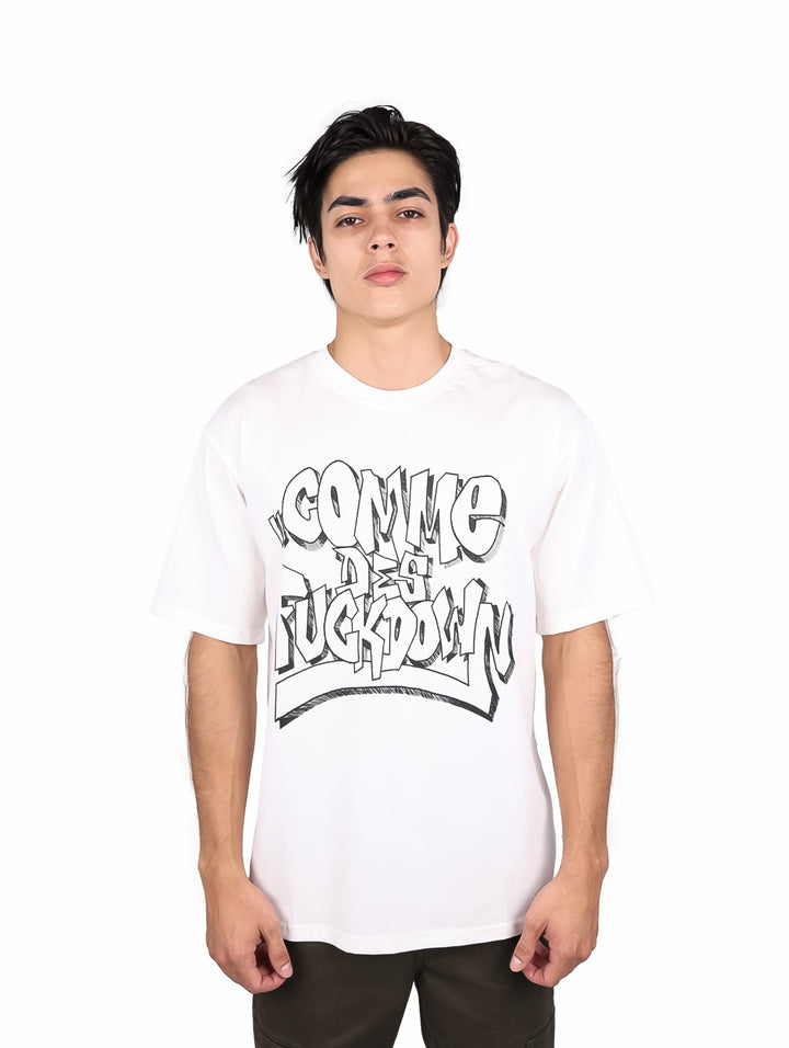 Hombre vistiendo playera blanca oversize de manga corta con estampado gráfico negro en el pecho.