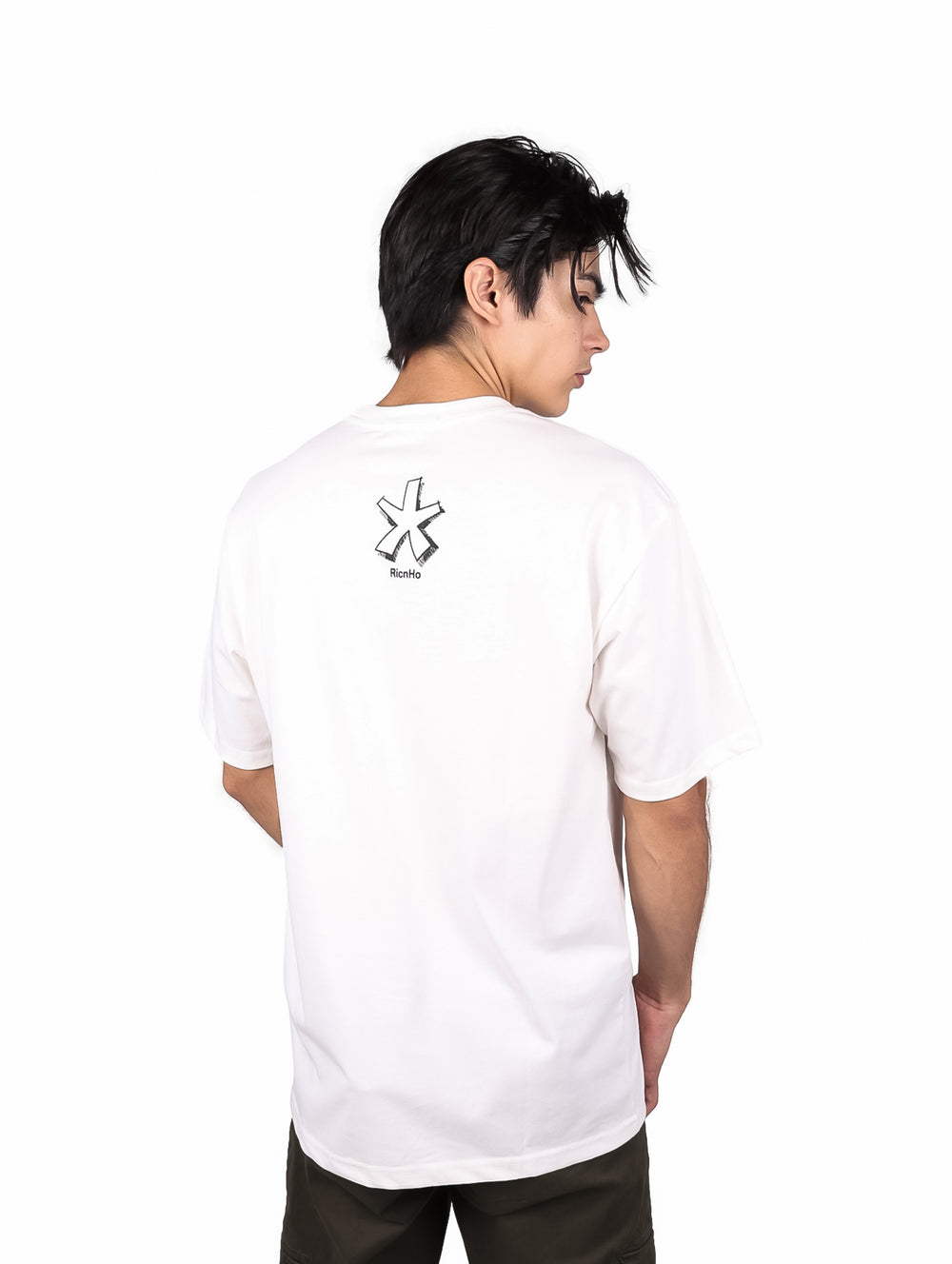 Hombre vistiendo playera blanca oversize de manga corta con estampado gráfico negro en el pecho.