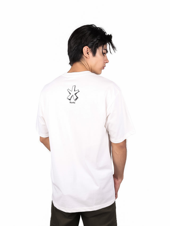 Hombre vistiendo playera blanca oversize de manga corta con estampado gráfico negro en el pecho.