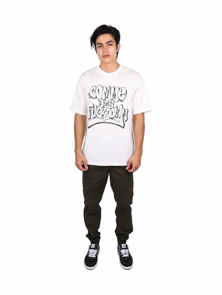 Hombre vistiendo playera blanca oversize de manga corta con estampado gráfico negro en el pecho.