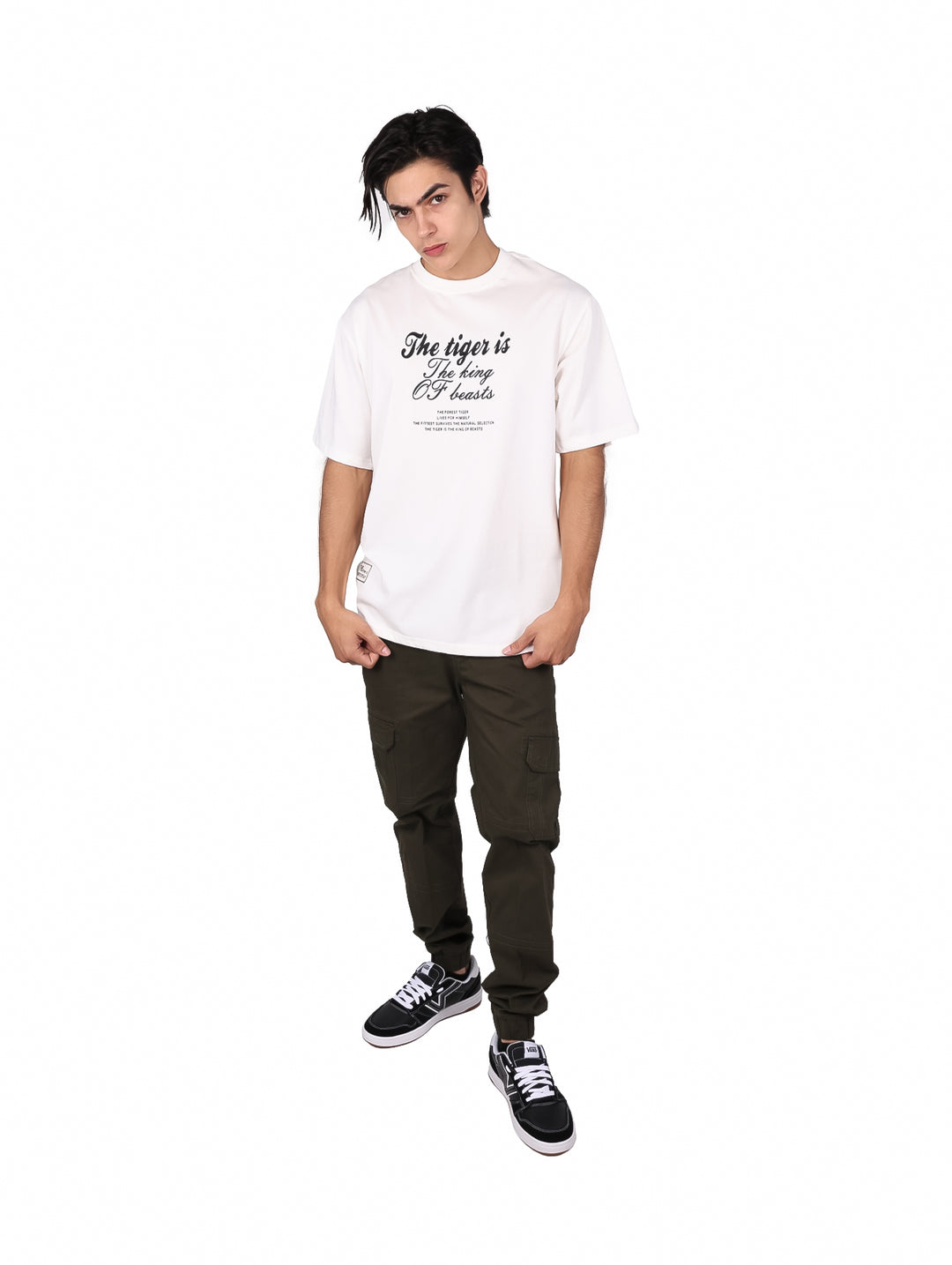 Hombre vistiendo playera blanca oversize de manga corta con estampado de texto negro en el pecho.