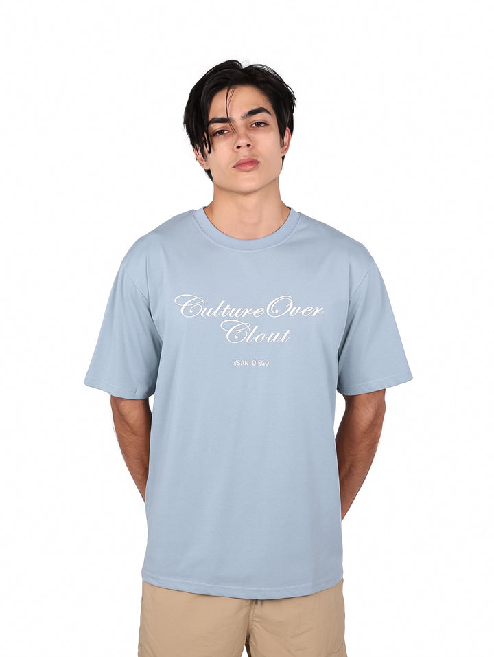 Playera oversize color azul claro con estampado blanco en el pecho.