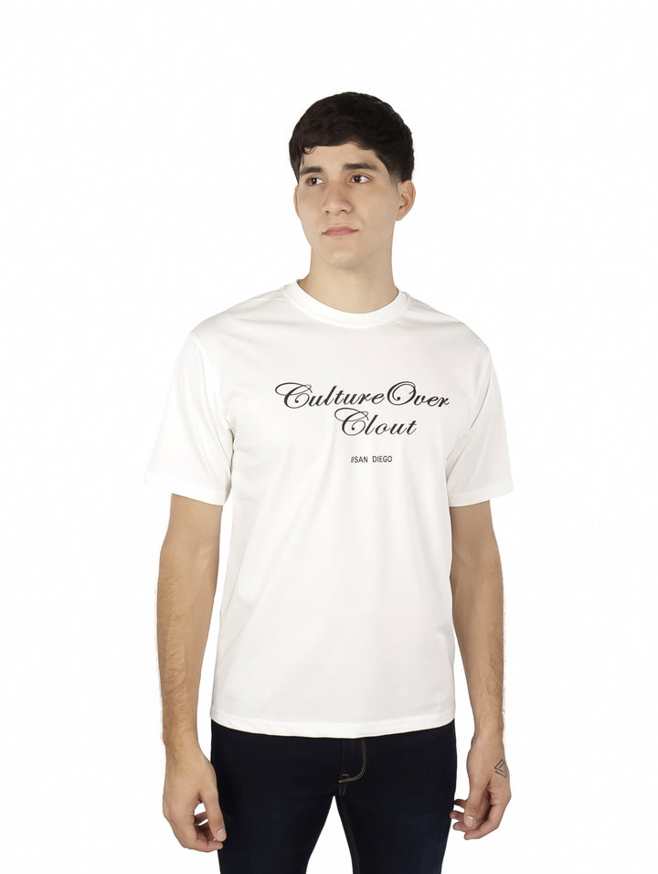 Hombre vistiendo playera blanca oversize de manga corta con estampado negro en el pecho.