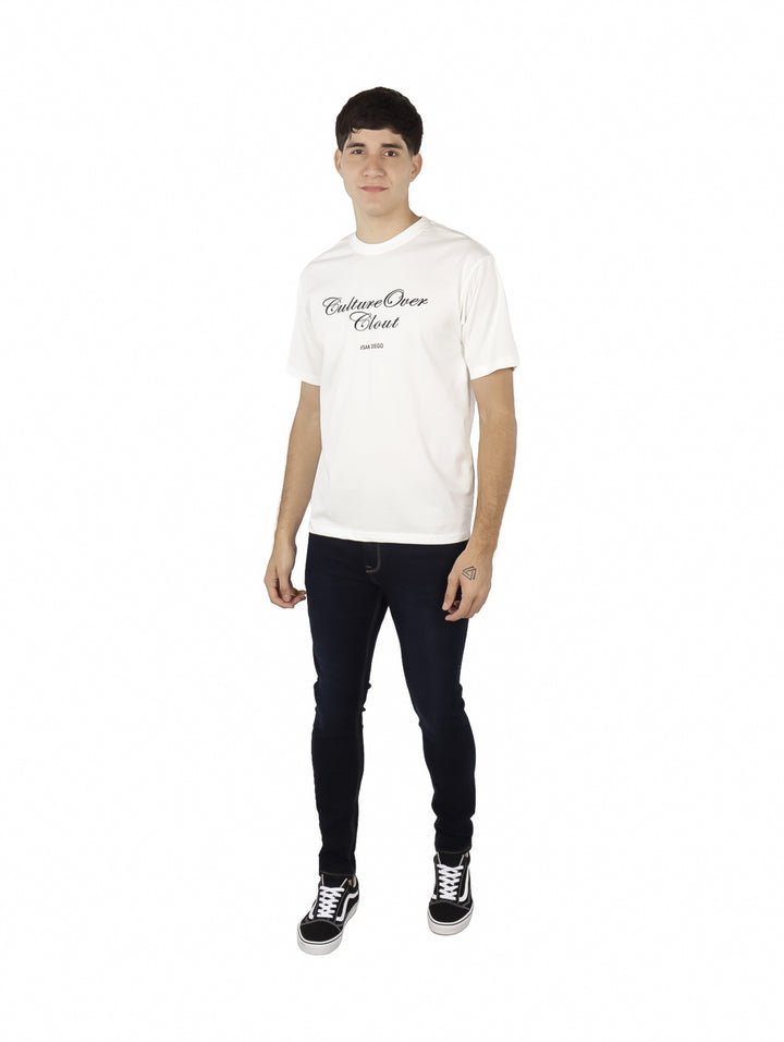 Hombre vistiendo playera blanca oversize de manga corta con estampado negro en el pecho.